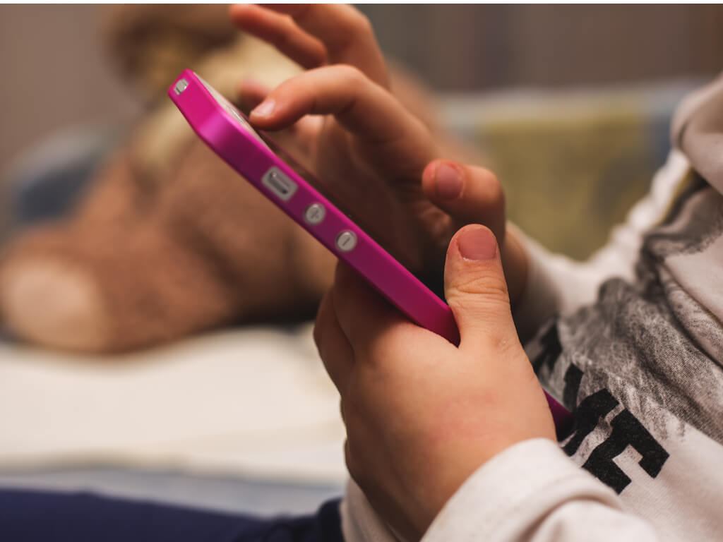 Teléfono celular en la mano de un niño.