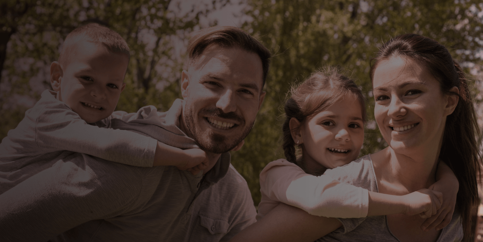 Pareja joven y sonriente con dos niños.