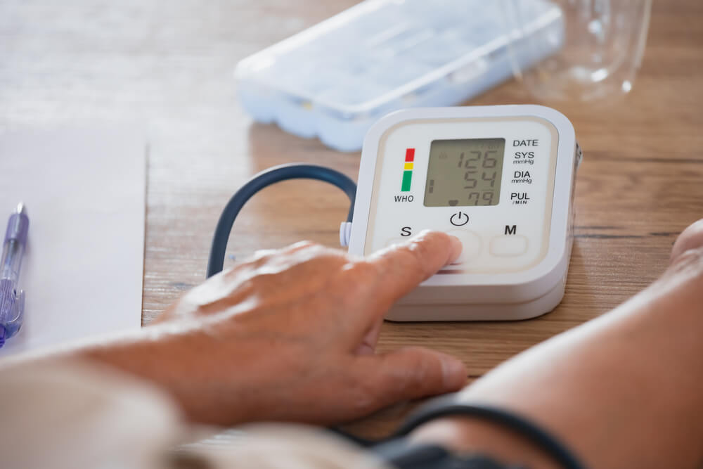Una mujer comprueba por sí misma la presión arterial y la frecuencia cardíaca con un manómetro digital